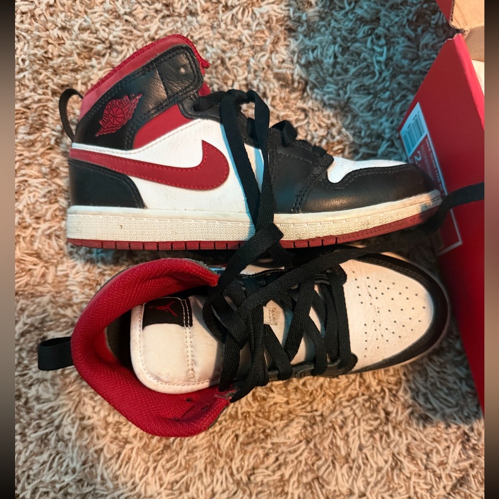 Nike Air Jordan 1 Mid in a black, white, and red colorway.